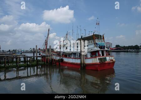 SAMUT SAKHON, THAÏLANDE - 09 octobre 2014 : la rivière Tha Chin avec des bateaux de pêche amarrés et un gangplank à l'avant, province de Samut Sakhon, en Thaïlande. Banque D'Images