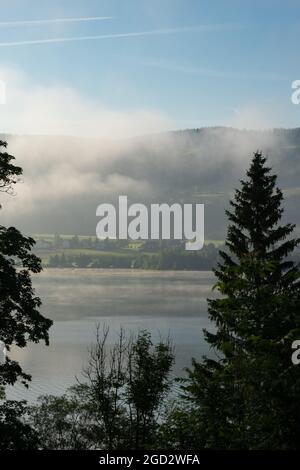 Vue en début de matinée sur le lac de Joux, Suisse, vers les montagnes brumeuses du Jura au lever du soleil Banque D'Images