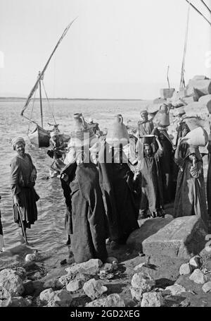 Les femmes autochtones avec des bocaux transportant l'eau du Nil quelque part en Egypte ca. 1900 Banque D'Images