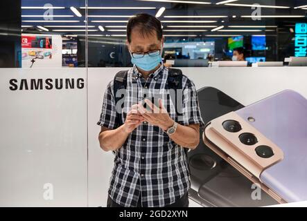 Hong Kong, Chine. 10 août 2021. Un homme utilise un smartphone devant une histoire de vente de l'électronique multinationale sud-coréenne Samsung Samsung Galaxy s21 5G smartphone à Hong Kong. (Photo de Budrul Chukrut/SOPA Images/Sipa USA) crédit: SIPA USA/Alay Live News Banque D'Images