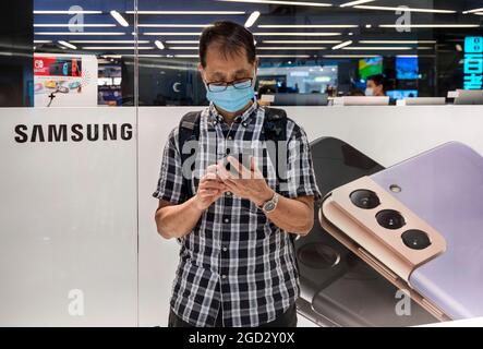 Hong Kong, Chine. 7 août 2021. Un homme utilise un smartphone devant une histoire de vente de l'électronique multinationale sud-coréenne Samsung Samsung Galaxy s21 5G smartphone à Hong Kong. (Credit image: © Budrul Chukrut/SOPA Images via ZUMA Press Wire) Banque D'Images