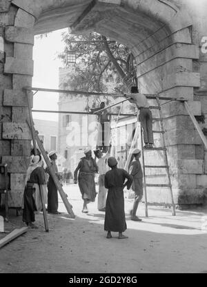 Les employés qui mettent des portes en fer à la nouvelle porte (oct 21, 1937) environ 1937 Banque D'Images