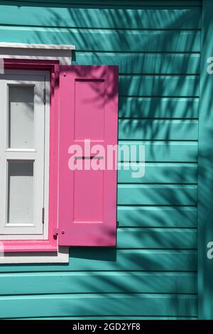 Bâtiment et fenêtre turquoise aux couleurs des Caraïbes avec volets roses Banque D'Images