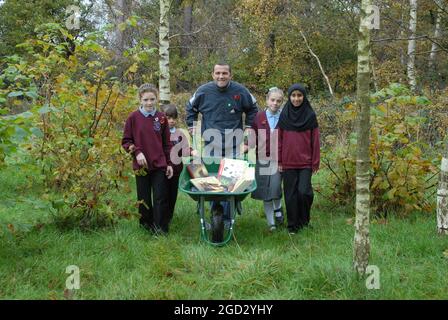 BLUE PETER GARDENER CHRIS COLLINS AVEC DES ÉLÈVES À L'ÉCOLE BORDON JUNIOR DANS LE JARDIN DE LECTURE. DE GAUCHE À DROITE, ISABELLE CRAWFORD, LAUREN WRIGHT, CHRIS COLLINS, TAMARA LAWRENCE ET FAWZIYYAH PIC MIKE WALKER 2008 Banque D'Images