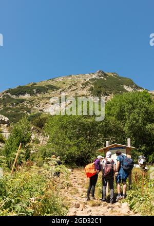 Randonneurs explorant la carte des itinéraires de randonnée au pied du pic de Vihren dans le parc national et réserve de Pirin, montagne de Pirin, Bulgarie, Balkans, Europe Banque D'Images