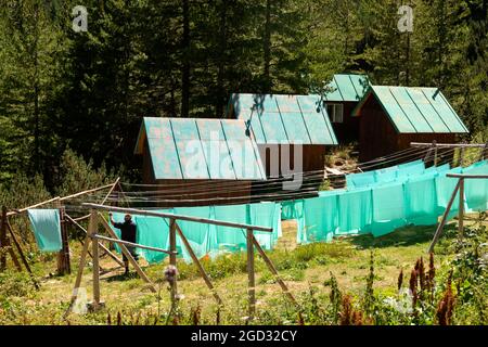 Linge de draps verts fraîchement lavés, séchage sur corde à linge à l'extérieur à Vihren Hut dans le parc national et réserve de Pirin, Pirin Mountain, Bulgarie, Balkans Banque D'Images