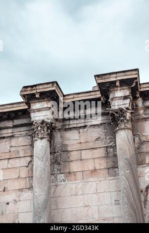 Mur de la bibliothèque d'Hadrien marbre vert colonnes corinthiennes gros plan. Détails de l'architecture de la colonnade grecque ancienne à Athènes, Grèce. Vue verticale sur bleu Banque D'Images