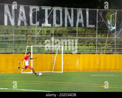 Medellin, Antioquia, Colombie - juillet 30 2021 : un jeune adolescent latin de Sportswear pratique Kicking a ball sur un champ d'herbe synthétique Banque D'Images