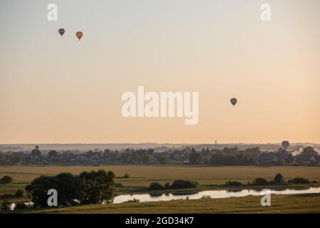 Des ballons d'air chaud colorés s'envolent dans le ciel au crépuscule ou à l'aube. Survolez le brouillard au lever ou au coucher du soleil avec un magnifique fond de ciel. Voyages et tourisme Banque D'Images