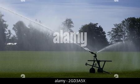 L'arroseur de champ à volume élevé irrigue le champ de la ferme dans le centre de Saanich. Banque D'Images