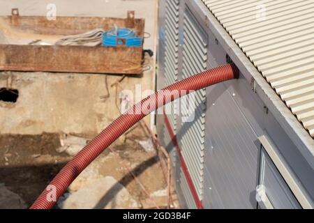 Un câble ondulé. Le câble entre dans la structure. Vrai pour l'électricité. Le courant se trouve sur le chantier de construction. Banque D'Images