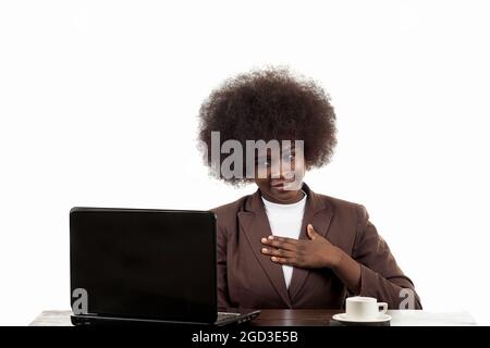 Jeune femme d'affaires noire hispanique Latina, avec cheveux afro, avec un geste confiant regardant son ordinateur portable, sur fond blanc Banque D'Images