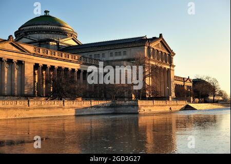 Chicago, Illinois, États-Unis. Musée des sciences et de l'industrie se reflétant dans un étang encore gelé juste après le lever du soleil. Banque D'Images