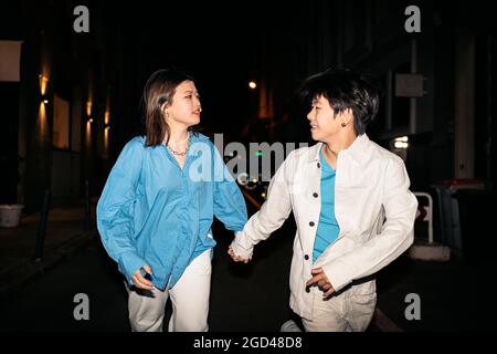 Cool jeune asiatique couple marchant dans la ville de Madrid la nuit et s'amuser. Banque D'Images