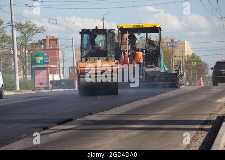 Tula, Russie - 16 mai 2021 : procédé d'asphaltage, machine à finisseur et deux rouleaux routiers pendant les travaux de construction de routes, travaillant sur la nouvelle route Banque D'Images