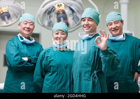 L'équipe médicale qui fait bien signe dans la salle d'opération Banque D'Images