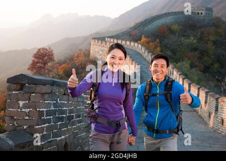 Un jeune couple fait le pouce sur la Grande Muraille Banque D'Images