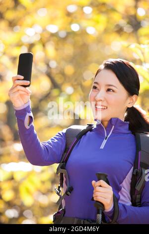 Bonne femme routard prendre des photos avec un smartphone Banque D'Images