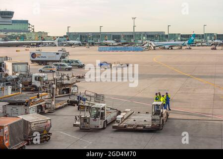 Aéroport avec véhicules de travail et personnel Banque D'Images