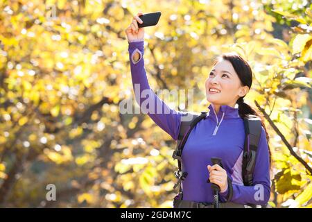 Bonne femme routard prendre des photos avec un smartphone Banque D'Images