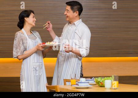 Couple d'âge mûr préparant le dîner dans la cuisine Banque D'Images