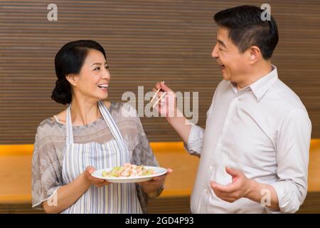 Couple d'âge mûr préparant le dîner dans la cuisine Banque D'Images