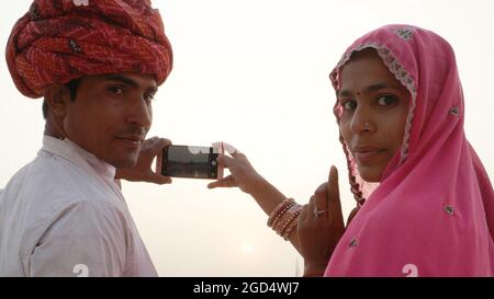 Gros plan d'un couple indien en costume traditionnel prenant des photos avec le smartphone. Banque D'Images