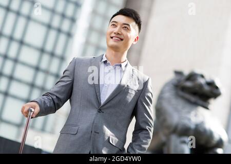 Homme d'affaires joyeux devant la banque Banque D'Images