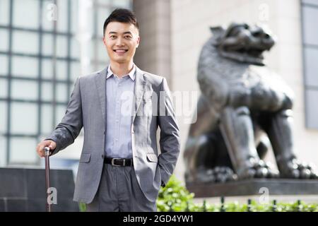 Homme d'affaires joyeux devant la banque Banque D'Images