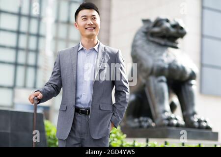 Homme d'affaires joyeux devant la banque Banque D'Images