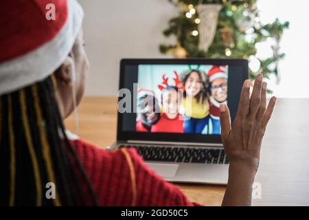 Femme africaine senior faisant appel vidéo avec sa famille pendant les fêtes - Focus sur la droite Banque D'Images