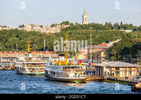 ISTANBUL, TURQUIE - 07,01,2015: Ferries dans le port d'Eminonu le palais de Topkapi à l'arrière Istanbul, Turquie Banque D'Images