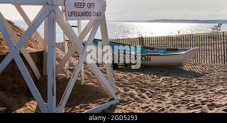 Un stand de sauveteurs blancs et une barque sur la neach tôt le matin au parc national Sunken Meadow, sur le long Island Sound. Banque D'Images