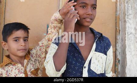 Gros plan de deux jeunes garçons indiens. Un jeune garçon parle au téléphone. Banque D'Images