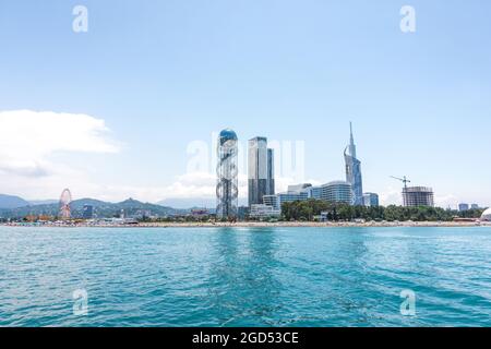 Batumi, Géorgie - 2 juillet 2021 : littoral de Batumi. Station balnéaire géorgienne populaire à la mer Noire. Vue panoramique sur la grande roue, la tour alphabétique, les gratte-ciels et la plage depuis la mer. Banque D'Images