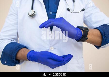 Les mains du médecin dans des gants médicaux montrant le signe Banque D'Images