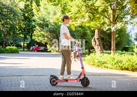 Un jeune homme conduit un scooter électrique loué dans le parc. Partage de scooter. Rostov-sur-le-Don, Russie, août 07 2021 Banque D'Images