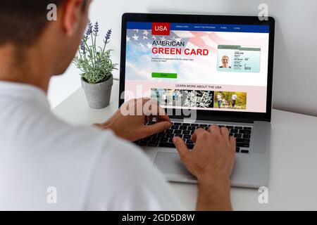 Homme avec ordinateur portable avec le site Web de la carte de résident permanent des États-Unis Banque D'Images