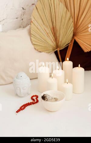 Lieu de méditation avec des bougies allumées et sauge blanche bâton avec la fumée sortant, petite statue de la tête de bourgehas, aromathérapie avec nettoyage de Banque D'Images