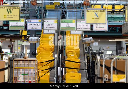 11 août 2021, Brandebourg, Stahnsdorf: Des boîtes en plastique jaune sont déplacées par des courroies transporteuses au centre de courrier et de colis de Deutsche Post. Depuis 25 ans, Deutsche Post utilise le centre pour livrer des lettres aux clients de la grande région de Potsdam et des quartiers sud-ouest de Berlin. En attendant, de moins en moins de lettres sont envoyées, mais d'autant plus de colis et de colis. Un nouveau trieur multi-format trie également ces colis de petit format avec une épaisseur maximale de dix centimètres et un poids de 2,000 grammes, qui peuvent ensuite être livrés par le transporteur de lettres dans le réseau de lettres. Photo : Banque D'Images