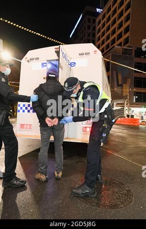 Melbourne, Australie, 11 août 2021. Un manifestant est fouillé avant d'être chargé dans une camionnette de police après avoir été arrêté pour avoir refusé de produire une pièce d'identité lors d'une tentative de protestation rapide, le 6ème confinement étant prolongé à travers Melbourne pendant 7 jours supplémentaires. Des manifestants anti-verrouillage et anti-vaccination ont joué au chat et à la souris avec la police et ont été détenus et condamnés à une amende avant qu'une manifestation ne puisse avoir lieu. Crédit : Michael Currie/Speed Media/Alay Live News Banque D'Images