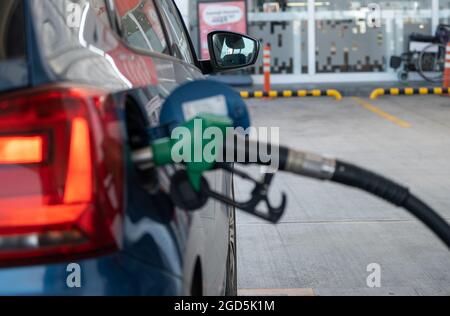 Faites le plein de la voiture bleue dans la station-service, en fulant le pétrole Banque D'Images