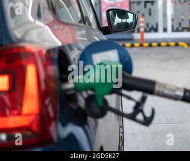 Faites le plein de la voiture bleue dans la station-service, en fulant le pétrole Banque D'Images