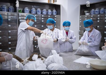 Zhangjiajie, province chinoise du Hunan. 11 août 2021. Les pharmaciens emballez la médecine traditionnelle chinoise (MCT) dans un hôpital de TCM à Zhangjiajie, dans la province du Hunan, au centre de la Chine, le 11 août 2021. Plus de 12,000 doses de décoctions de TCM sont faites par l'hôpital chaque jour pour aider à contrôler la pointe récente des infections à COVID-19 dans Zhangjiajie. Credit: Chen Sihan/Xinhua/Alay Live News Banque D'Images