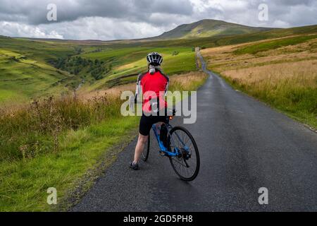 Cycliste sur la route Stainforth jusqu'à Halton Gill Road, Yorkshire Dales, Royaume-Uni. Banque D'Images