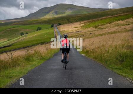 Cycliste sur la route Stainforth jusqu'à Halton Gill Road, Yorkshire Dales, Royaume-Uni. Banque D'Images