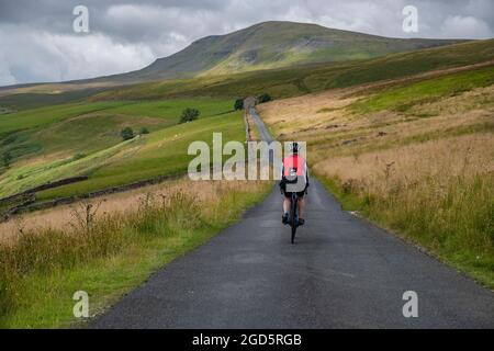 Cycliste sur la route Stainforth jusqu'à Halton Gill Road, Yorkshire Dales, Royaume-Uni. Banque D'Images