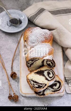 Gâteau avec garniture de pavot et têtes de graines sur fond de béton gris. Style rustique. Banque D'Images