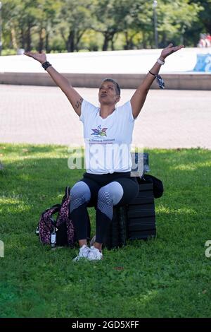 Un instructeur de yoga et de bien-être d'âge moyen levant les bras dans une classe à Flushing Meadows Corona Park dans le Queens. Banque D'Images