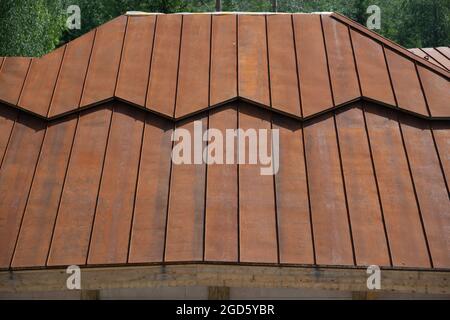 Pente métallique rouge rouillé d'un toit, photo d'arrière-plan Banque D'Images